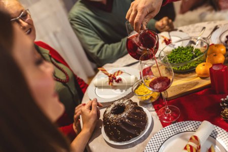 Photo for Happy family having Vhristmas dinner with their grandparents. Eating homemade food, drinking beverages. Home is decorated for New Year's Eve and Christmas - Royalty Free Image