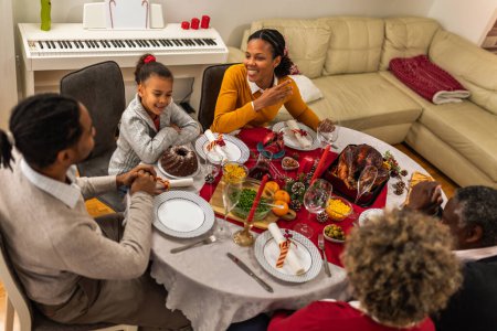 Photo for Parents bonding with their daughter on a Christmas Eve dinner. - Royalty Free Image