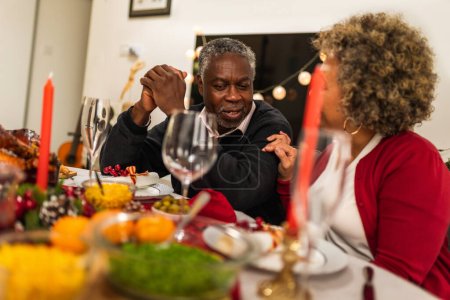 Téléchargez les photos : Les grands-parents parlent au dîner de Noël. - en image libre de droit