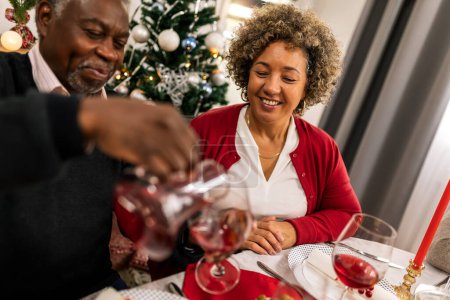 Photo for Grandparents drinking wine on the family Christmas dinner. - Royalty Free Image