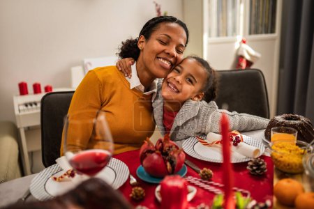 Photo for Mother bonding with her daughter on a Christmas Eve dinner. - Royalty Free Image