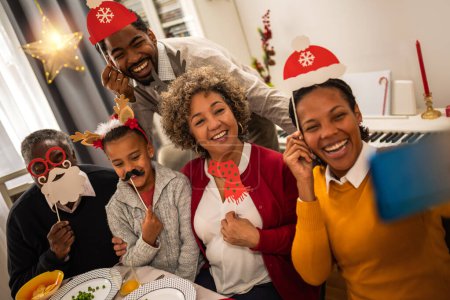 Photo for Family having good time with fun glasses, hats, mouth..Christmas time. - Royalty Free Image