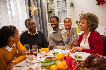 Téléchargez les photos : Famille s'amuser la veille de Noël à la table. - en image libre de droit