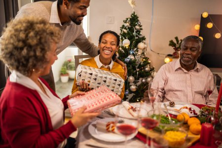 Photo for Giving gifts to the grandparents on Christmas dinner. - Royalty Free Image