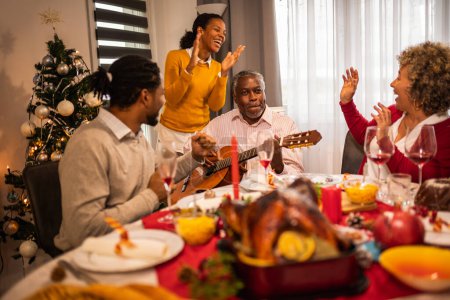Téléchargez les photos : Famille afro-américaine jouer de la guitare et chanter la veille de Noël. - en image libre de droit