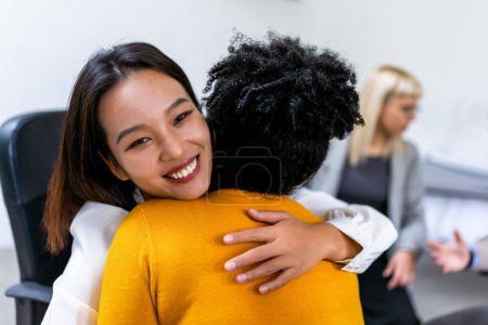 Foto de Dos mujeres abrazándose en una sesión de terapia de grupo, superando problemas juntas - Imagen libre de derechos