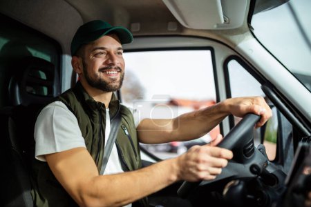 Téléchargez les photos : Jeune homme beau qui travaille dans le service de remorquage et de conduire sa camion. - en image libre de droit