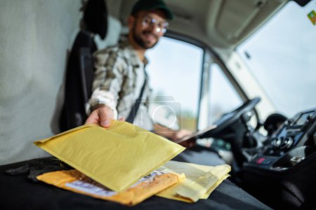 Photo for Young handsome delivery guy getting his deliveries ready - Royalty Free Image