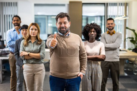 Téléchargez les photos : Patron debout devant ses collègues dans le bureau avec les pouces levés - en image libre de droit