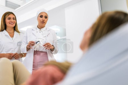 Photo for The dermatologist examines the moles or acne of the patient with a dermatoscope. Prevention of melanoma - Royalty Free Image