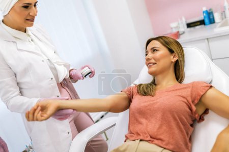 Photo for The dermatologist examines the moles or acne of the patient with a dermatoscope. Prevention of melanoma - Royalty Free Image