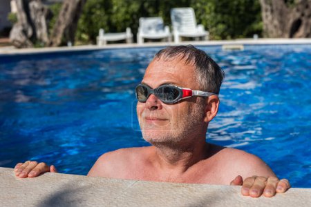 Foto de Hombre de mediana edad preparándose para nadar en la piscina con gafas. - Imagen libre de derechos