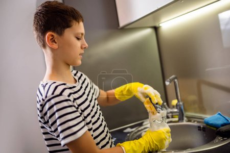 Foto de Niño lavar los platos en el fregadero y divertirse - Imagen libre de derechos