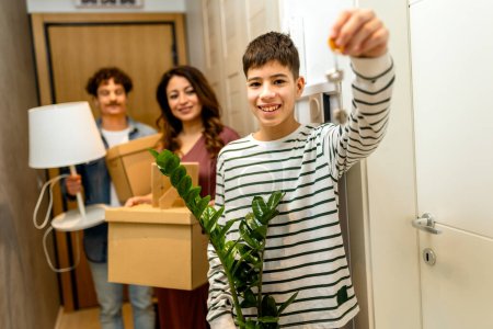 Téléchargez les photos : Famille latino emménager dans un nouvel appartement, tenant des boîtes et des plantes. - en image libre de droit