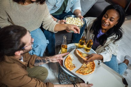 Téléchargez les photos : Groupe multiracial d'amis ayant pizza party. - en image libre de droit