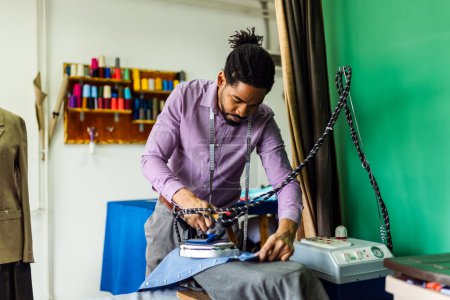 Foto de Camisa de planchar joven de sastre afroamericano en su taller. - Imagen libre de derechos