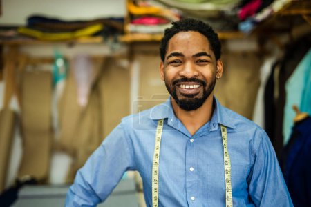 Foto de Joven sastre afroamericano sonriendo en su propio taller. - Imagen libre de derechos