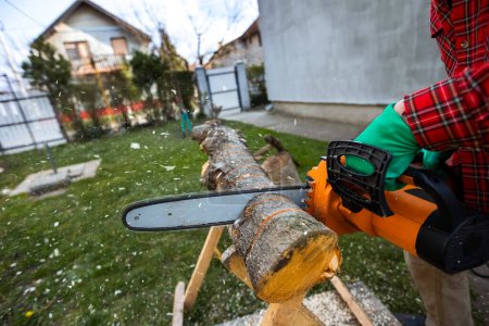 Foto de Hombre cortando madera con sierra, polvo y movimientos. Sierra de cadena
. - Imagen libre de derechos