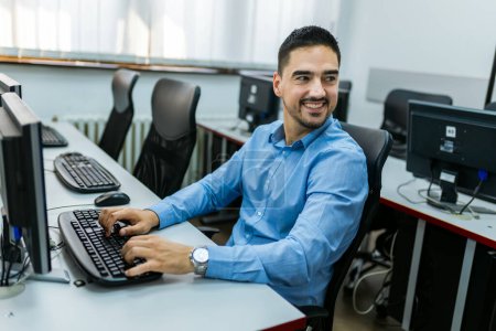 Foto de Estudiante masculino usando PC de escritorio en laboratorio de computación. - Imagen libre de derechos