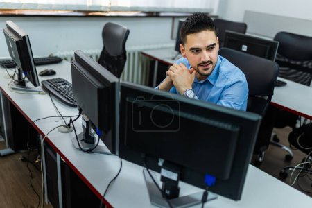 Photo for Male student using desktop PC in computer lab. - Royalty Free Image