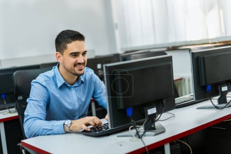 Photo for Male student using desktop PC in computer lab. - Royalty Free Image