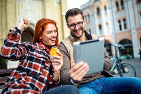 Téléchargez les photos : Jeune couple branché en ville avec tablette et carte de crédit. - en image libre de droit