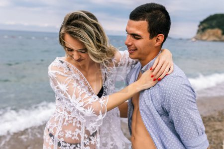 Photo for Happy young couple laughing and hugging on the beach - Royalty Free Image