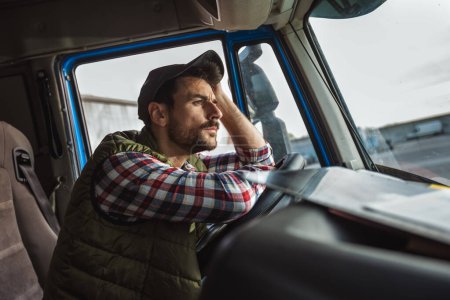 Photo for A tired truck driver takes a break from driving and rests in his truck - Royalty Free Image