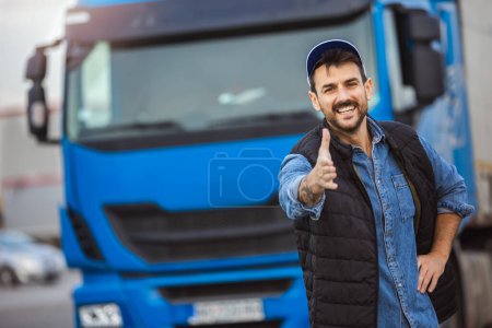 Téléchargez les photos : Conducteur masculin heureux et confiant debout devant sur son long véhicule prêt à conduire. - en image libre de droit