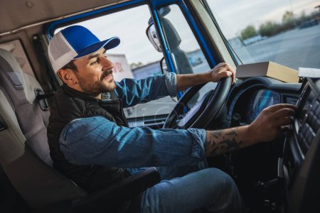 Téléchargez les photos : Jeune homme beau qui travaille dans le service de remorquage et de conduire sa camion. - en image libre de droit
