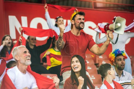 Photo for Football / soccer fans are cheering for their team at the stadium on the match. The cheer leader uses a megaphone - Royalty Free Image