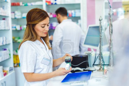 Téléchargez les photos : Prix de balayage du pharmacien sur une boîte à médicaments avec lecteur de codes à barres dans un magasin de pharmacie. - en image libre de droit