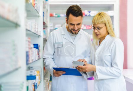 Téléchargez les photos : Pharmaciens travaillant sur les étagères de la pharmacie, pharmacie. - en image libre de droit