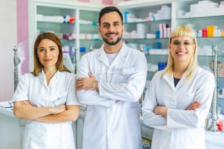 Photo for Portrait of three smiling pharmacists that are standing in the pharmacy. - Royalty Free Image