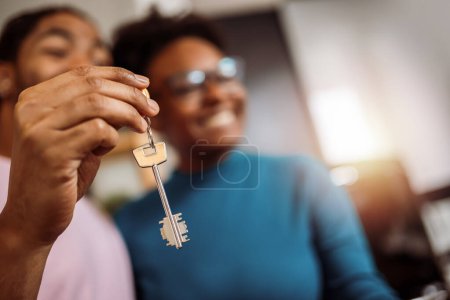 Téléchargez les photos : Gros plan des clés que le couple afro-américain a obtenues de leur agent immobilier pour leur nouvelle maison - en image libre de droit
