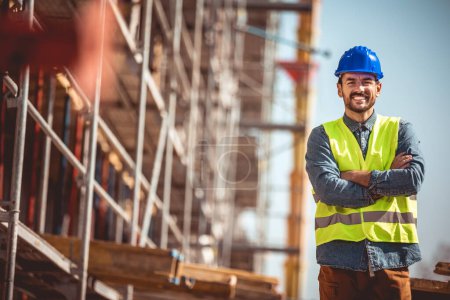 Photo for Construction site manager standing  wearing safety vest and helmet, thinking at construction site. Young architect watching construction site with confidence. - Royalty Free Image