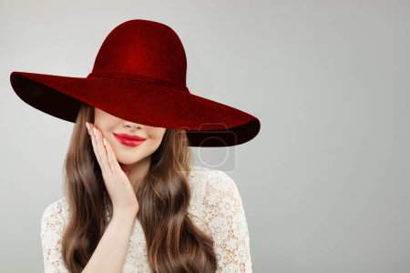 Foto de Mujer joven con sombrero ancho de ala ancha. Bonito modelo con labios rojos maquillaje y lindo retrato sonrisa - Imagen libre de derechos