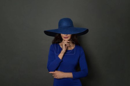 Foto de Hermosa mujer sonriente en amplio sombrero de ala ancha azul. Belleza, maquillaje y cosméticos . - Imagen libre de derechos