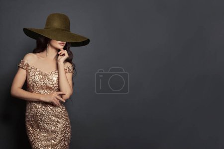 Foto de Joven morena modelo de moda mujer con sombrero de ala ancha marrón sobre fondo negro - Imagen libre de derechos