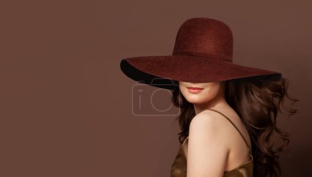 Foto de Mujer morena con el pelo rizado y con amplio retrato de sombrero de ala ancha marrón - Imagen libre de derechos