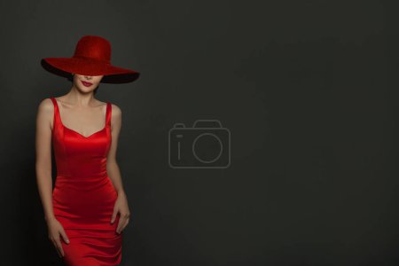 Foto de Sensual hermosa mujer morena posando en vestido rojo y sombrero de ala ancha rojo - Imagen libre de derechos