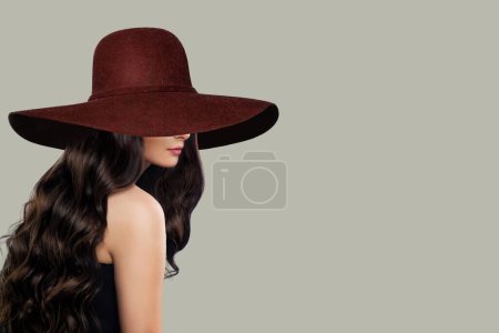 Foto de Mujer joven en vestido negro y amplio sombrero de ala ancha marrón Posando - Imagen libre de derechos