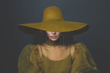 Foto de Mujer glamurosa morena con amplio sombrero de ala ancha sobre fondo negro - Imagen libre de derechos