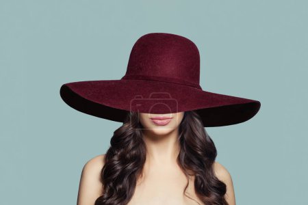 Foto de Mujer agradable en sombrero rojo ancho sobre fondo azul - Imagen libre de derechos