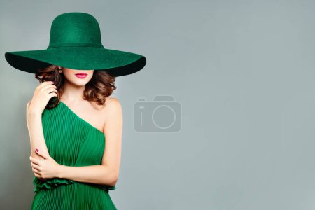 Foto de Retrato de la mujer bonita en vestido de moda y sombrero de ala ancha verde - Imagen libre de derechos