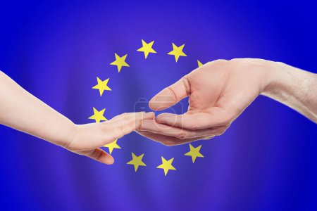 Téléchargez les photos : Bébé et parents de l'UE mains sur le fond du drapeau de l'Union européenne Aide, aide, soutien, concept de charité - en image libre de droit