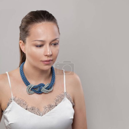Photo for Blue and grey necklace on neck of attractive woman - Royalty Free Image