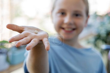 Photo for Milk tooth fell out on hand of adorable child girl. Dental hygiene concept - Royalty Free Image