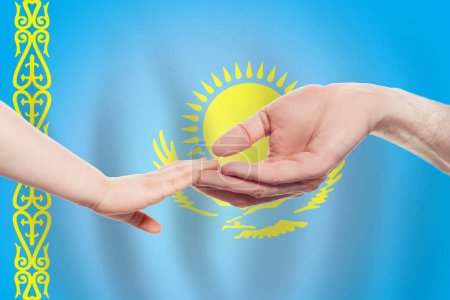 Foto de Kazakh baby and parent hands on the background of flag of Kazakhstan Ayuda, ayuda, apoyo, concepto de caridad - Imagen libre de derechos