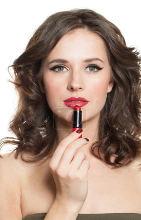 Téléchargez les photos : Belle femme brune peint ses lèvres avec du rouge à lèvres, gros plan portrait de beauté - en image libre de droit